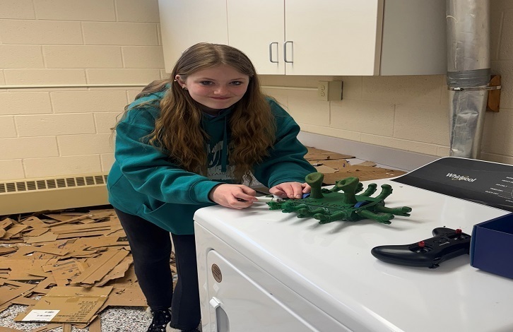 Middle school student putting the final touches on her Shrek Battle Box