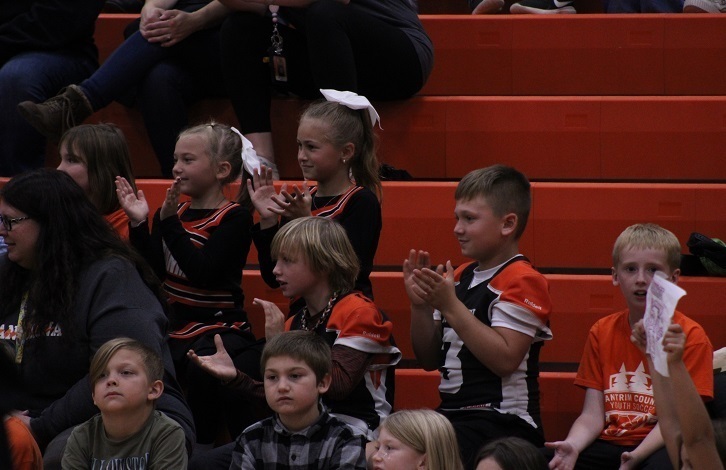 young cheerleaders and football players in the stands at the pep-assembly